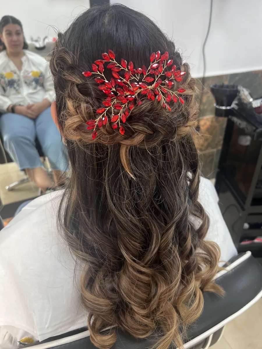 Recogido a media melena con trenza en cascada, ondas y un tocado de cristales rojos.