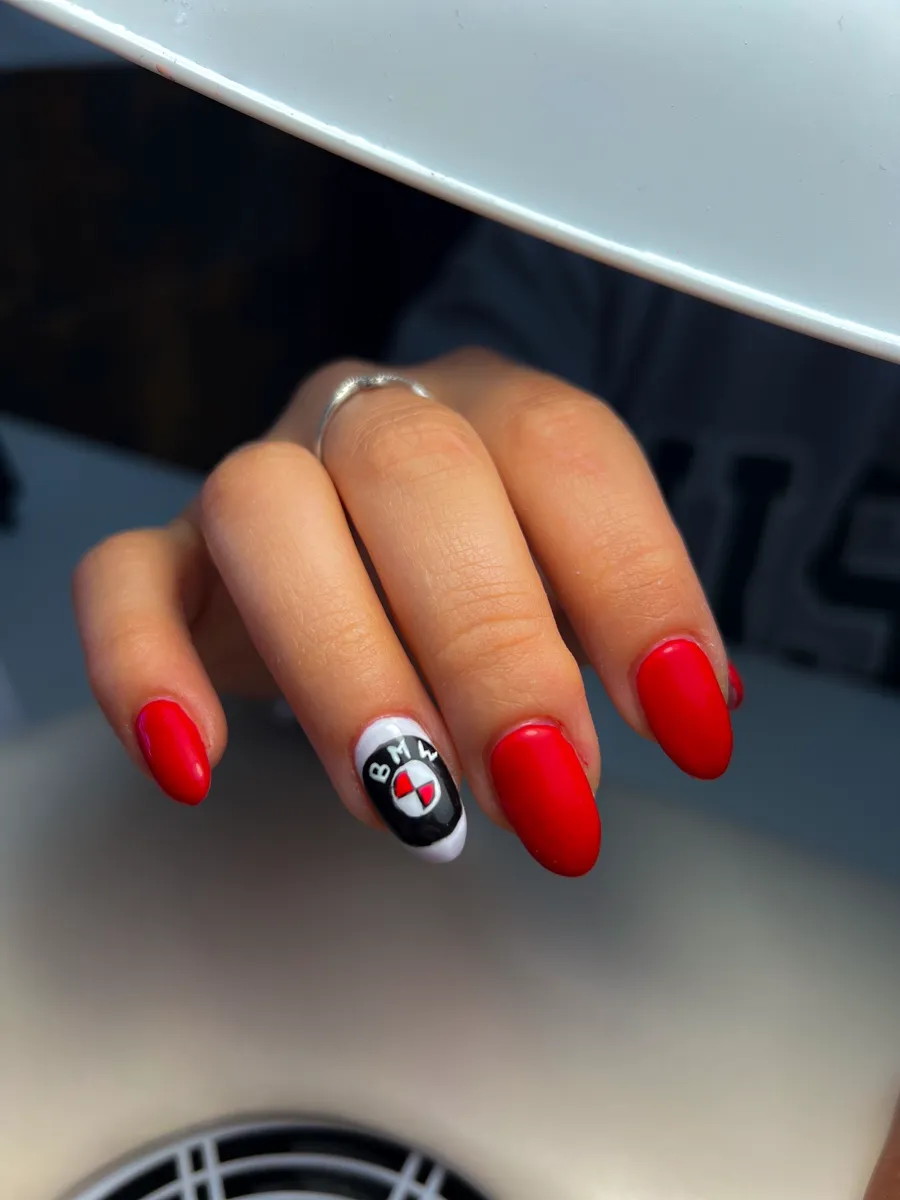 Manicura roja con una uña decorada en blanco y negro.